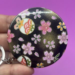 porte-clés badge (diamètre 58 mm) fond noir fleurs de Sakura
