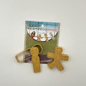 2 emporte-pieces: Kokeshi et Poupée de paille.